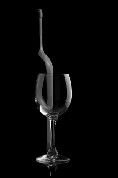 Elegantní víno láhev a sklenice na víno v černém pozadí — Stock fotografie