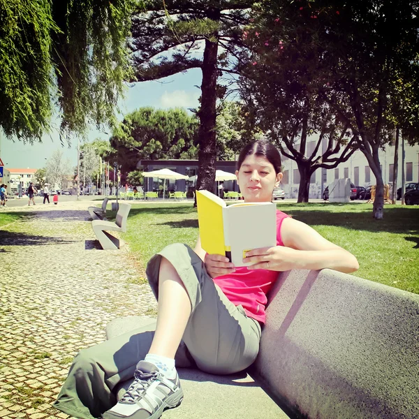 Woman reading book in park — Stock Photo, Image