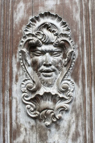 Face shaped decoration on a wooden door — Stock Photo, Image