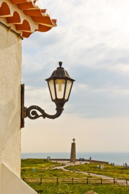 Streetlight on a wall and a view of Cabo da Roca (Cape Roca) clipart