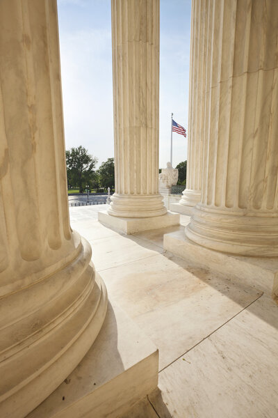 American flag viewed between pillars of Supreme Court building