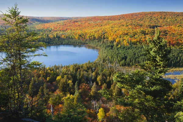 Blauwe meertje te midden van heuvels in herfst kleur — Stockfoto