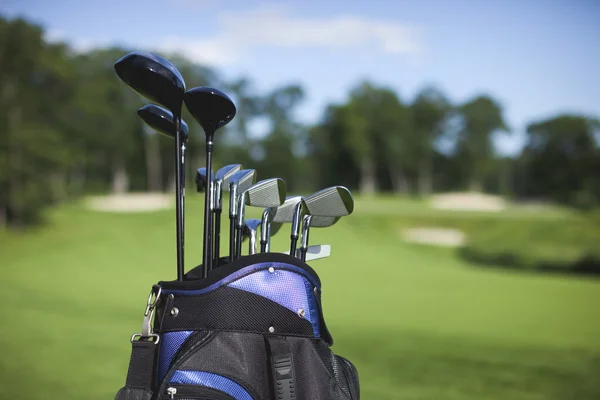 Saco de golfe e clubes contra fundo curso desfocado — Fotografia de Stock