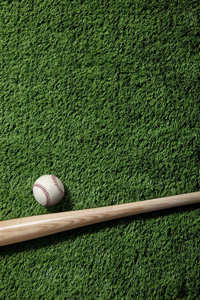 Overhead view of baseball and bat on green turf — Stock Photo, Image