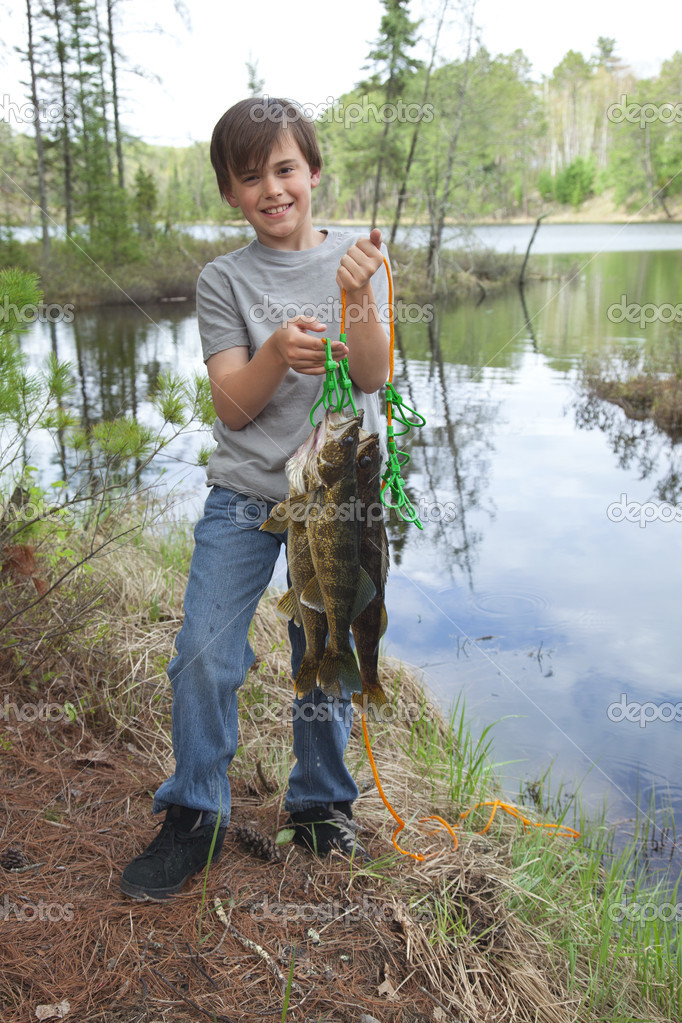 Young fisherman proudly holds up stringer of walleyes