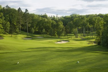 Golf green with bunkers in afternoon sunlight