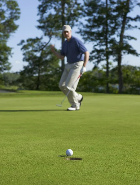 Golfista celebra afundando putt no verde — Fotografia de Stock