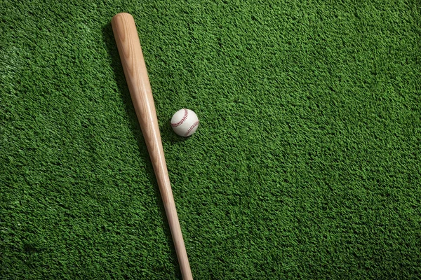 Baseball and bat on green turf viewed from above — Stock Photo, Image