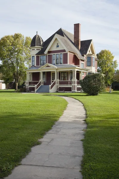 Casa vitoriana com gramado e calçada na tarde ensolarada — Fotografia de Stock