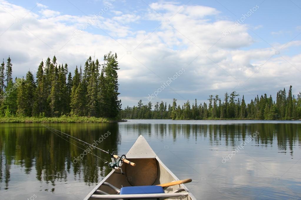 Canoe with fishing gear heading out on northern lake