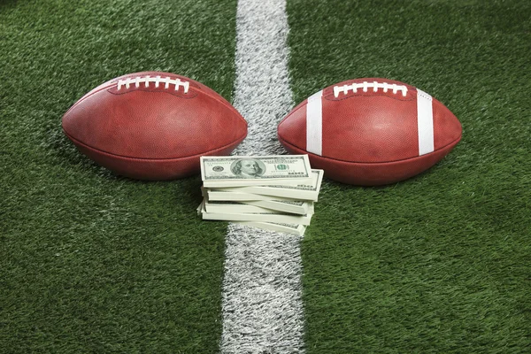 Balones de fútbol estilo profesional y universitario con dinero entre — Foto de Stock