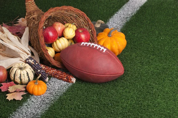 Football with a cornucopia on a grass field — Stock Photo, Image