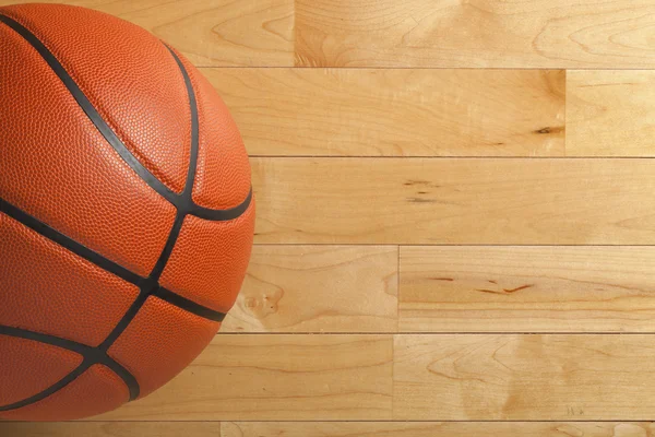 Basketball on wood gym floor viewed from above — Stock Photo, Image
