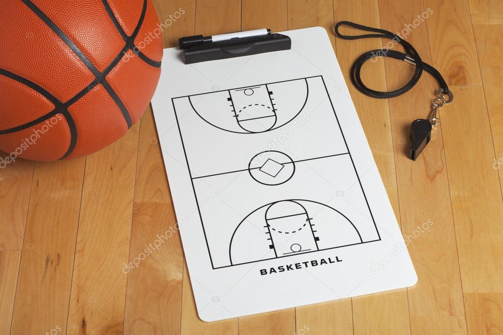 A basketball with coach's clipboard and whistle on a wooden gymn