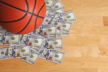 100 dolar faturaları yığını üzerinde basketbol