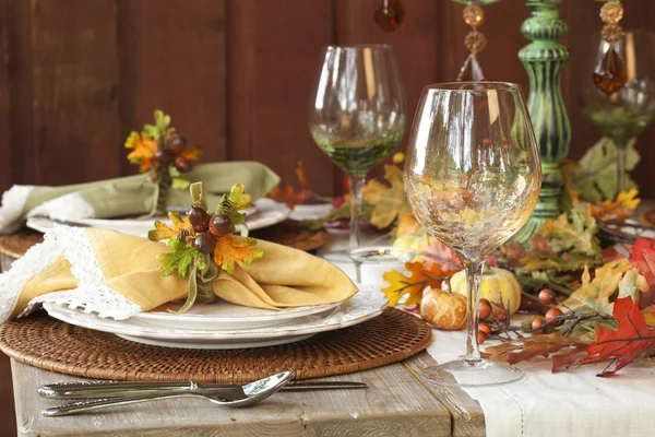 Fall dining place settings on rustic table and wall Stock Picture
