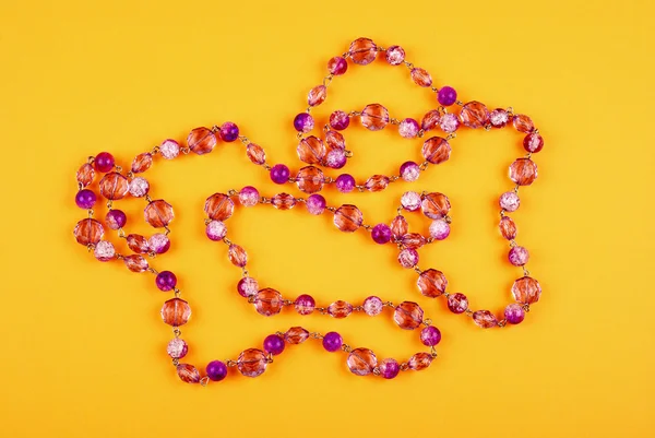 Pink necklace on yellow — Stock Photo, Image