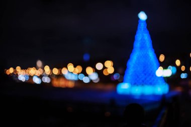 Şehirde şenlikli noel ışıkları, karanlık arka planda dekoratif fiber optik ışıklar.