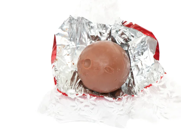 Chocolate candy unwrapped in golden foil — Stock Photo, Image
