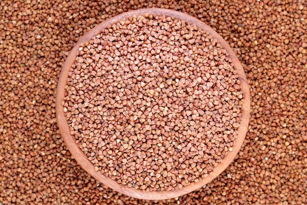 Raw buckwheat in a wooden bowl — Stock Photo, Image