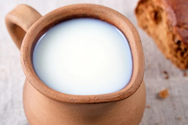 Keramische kruik met melk en vers brood — Stockfoto