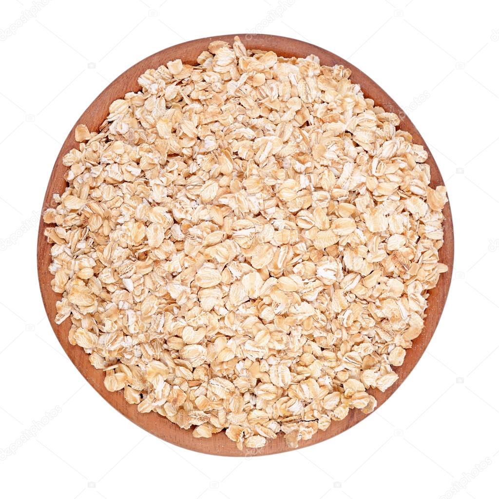 Oatmeal flakes in a wooden bowl on a white background