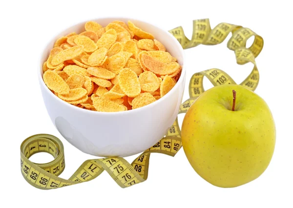 Green apple, bowl of cornflakes and measuring tape. — Stockfoto