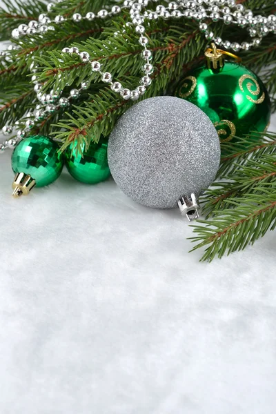 Christmas balls and garland on a spruce branch — Stock Photo, Image