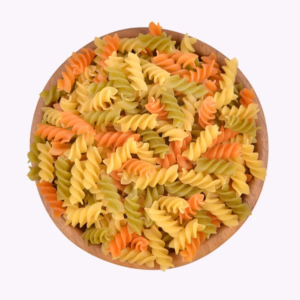 Italian pasta fusilli in a wooden bowl on a white background — Stock Photo, Image