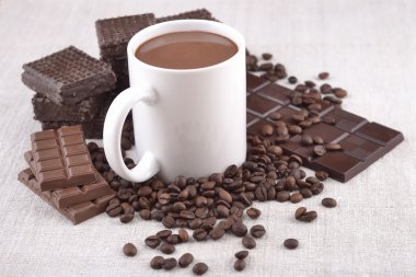 Beyaz fincan sıcak çikolata kahve çekirdekleri ve çikolata backgro