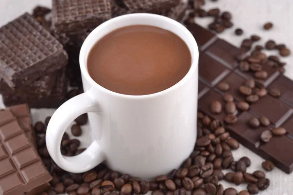 Coupe blanche de chocolat chaud sur les grains de café et le noir de chocolat — Photo