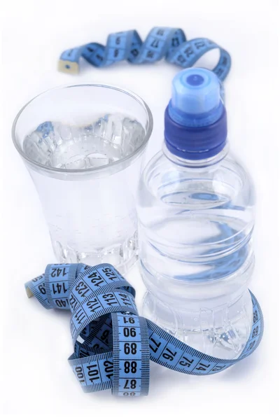 Bottle of water, glass of water and measuring tape — Stock Photo, Image