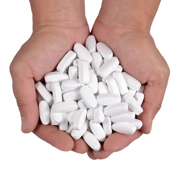 Pílulas brancas nas mãos em um branco — Fotografia de Stock