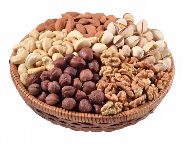 Assorted nuts in a wicker bowl on a white background — Stock Photo, Image