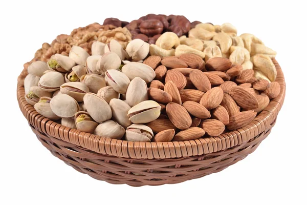 Verschiedene Nüsse in einer Weidenschale auf weißem Hintergrund — Stockfoto