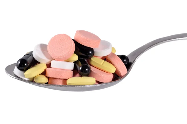Mnoho barevných pilulek v lžíce — Stock fotografie