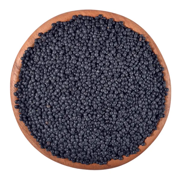 Black raw lentil in a wooden bowl on a white — Stock Photo, Image