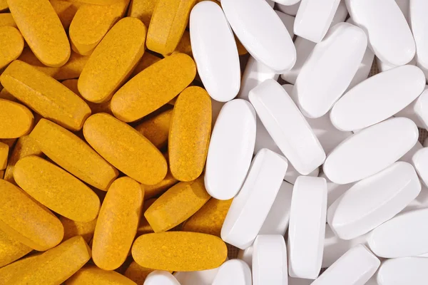 Белый и желтый таблетки фон — стоковое фото