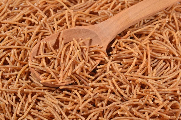 Целая пшеница сырой коричневый вермишель в ложке — стоковое фото