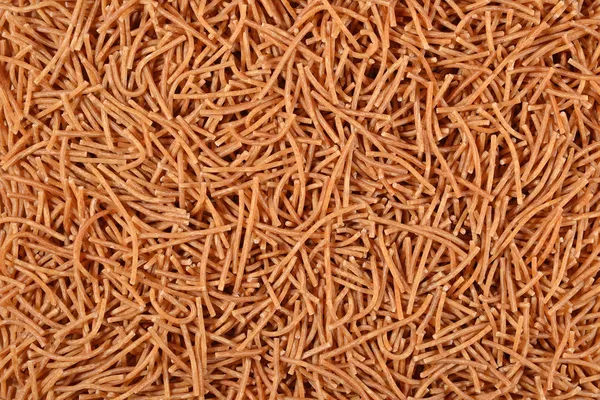 Pełnoziarniste niegotowane brązowy makaron tło — Zdjęcie stockowe