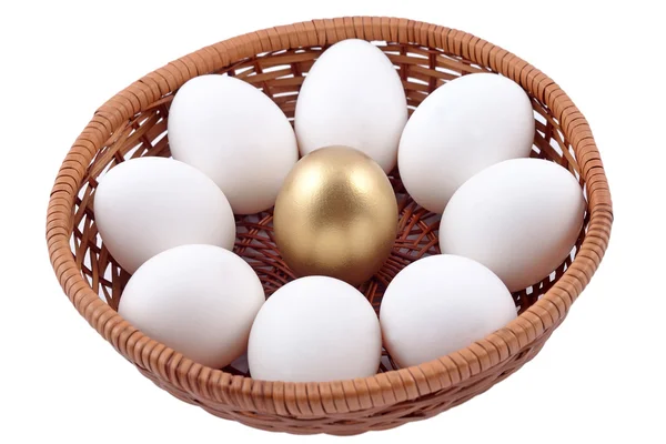 Золоте яйце і яєчня в плетеній мисці на білому — стокове фото