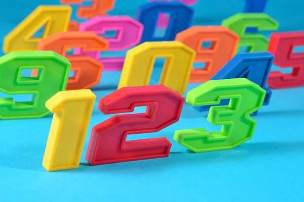 Números de plástico coloridos 123 em um fundo azul — Fotografia de Stock