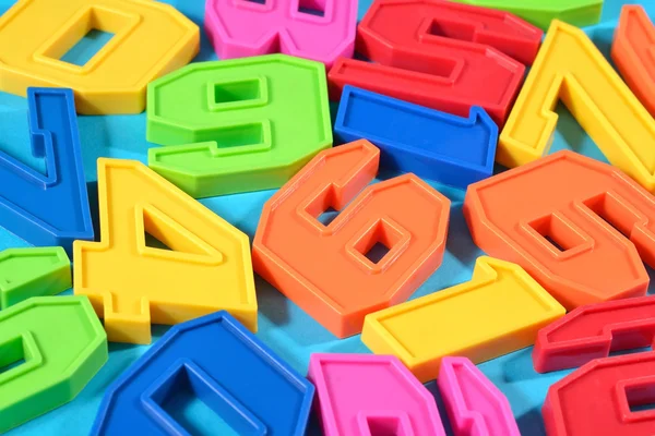 Plastic colored numbers on a blue background — Stock Photo, Image