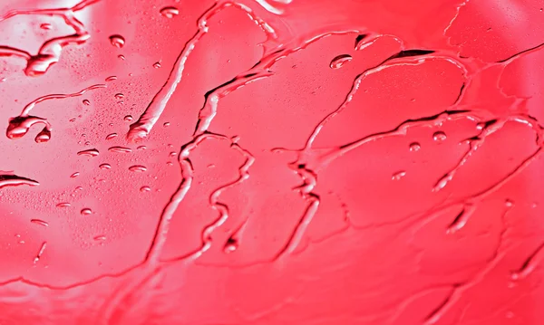 Gotas de agua en superficie roja abstracta — Foto de Stock