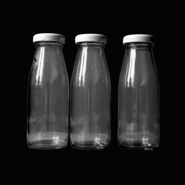 Üç şişe süt siyah arka plan üzerine