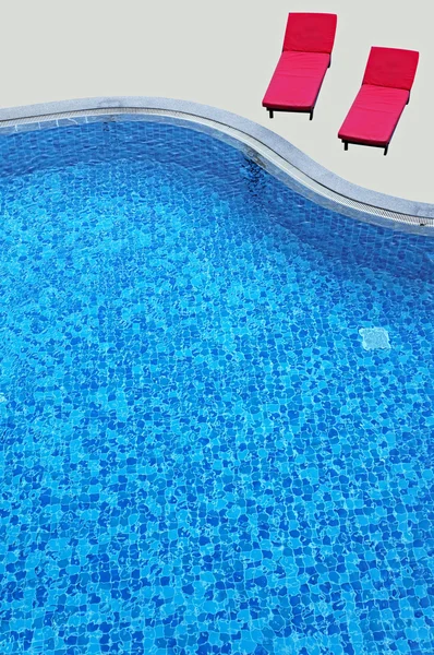 Esvaziar espreguiçadeiras vermelhas junto à piscina — Fotografia de Stock