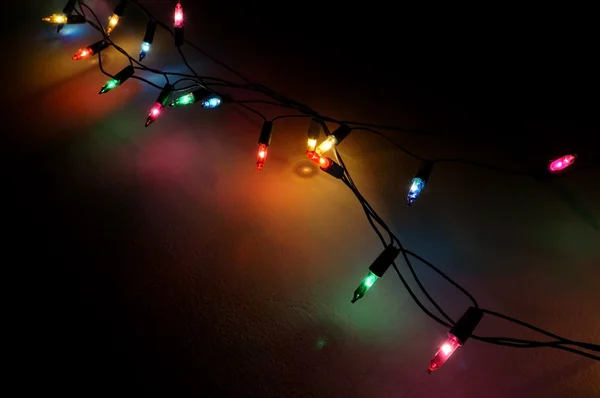 Luzes decorativas de Natal na parede à noite — Fotografia de Stock