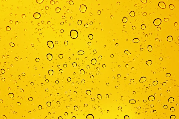 Gocce d'acqua su giallo — Foto Stock