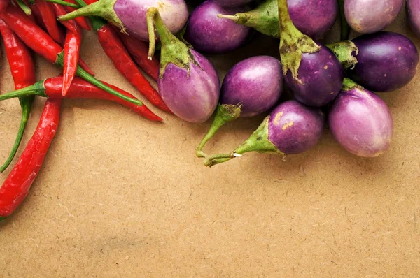 Red chili and tomatoes on wooden table — Stock Photo, Image