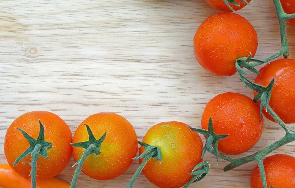 Zweig roter reifer Kirschtomaten auf einem Holzbrett — Stockfoto